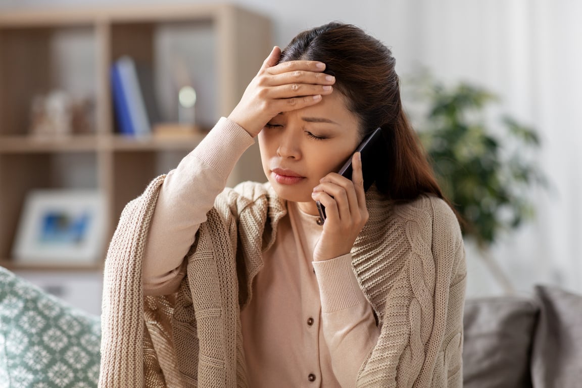 Sick Asian Woman Calling on Smartphone at Home