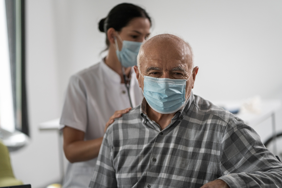 Female home caregiver with stethoscope in home visit